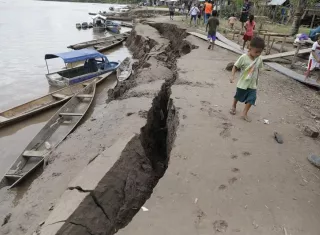Un niño camina cerca de una grieta en el suelo, causada por un terremoto de magnitud 7,5 en la escala de Richter este domingo, en Puerto Santa Gema, en la ciudad amazónica de Yurimaguas (Perú). EFE