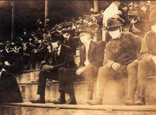 Público con mascarillas durante un partido entre equipos universitarios en 1918./ AP