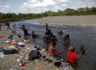 Migrantes haitianos se bañan en el río Tuquesa, en la comunidad de Bajo Chiquito, en Darién (Panamá). EFE/