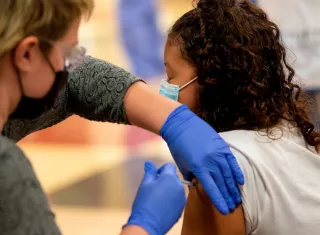 Una niña recibe una dosis de la vacuna de Pfizer-BioNTech contra la covid-19, en Everett, Massachusetts (EE.UU.). Fotografía de archivo. EFE