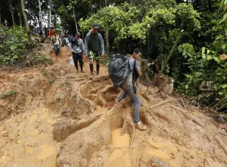 Migrantes venezolanos suben una montaña con la intención de llegar a Panamá. EFE