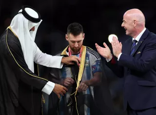 El emir  Tamim bin Hamad Al Thani (L) coloca el "bisht" a Messi. /EFE