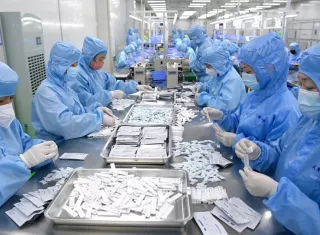 Los empleados producen kits de prueba de antígeno COVID-19 en una empresa de equipos médicos en Xi'an, provincia de Shaanxi, noroeste de China. EFE