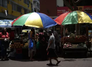 Personas caminan frente a puestos de buhonerías en la avenida Central en ciudad de Panamá. EFE