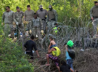 Militares observan a migrantes luego de cruzar el río Bravo para intentar ingresar a Estados Unidos en Matamoros (México). EFE
