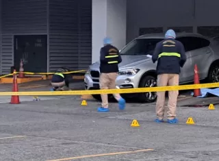 Escena del crimen en un estacionamiento de un comercio.
