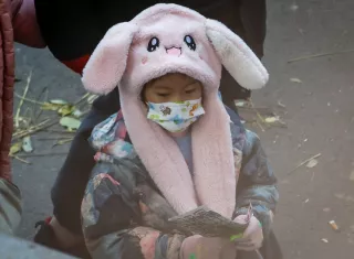 Un niño usa una mascarilla después de ser despedido de una escuela en Beijing, China
