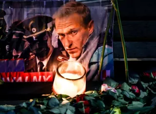 Un retrato del fallecido líder de la oposición rusa Alexei Navalny entre ofrendas florales y una vela frente a la embajada rusa en Berlín, Alemania. EFE