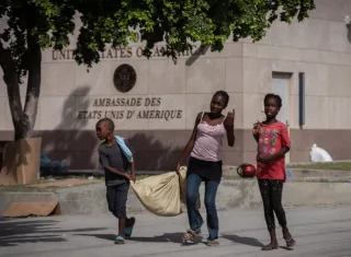 Personas caminan frente a la embajada de Estados Unidos, en Puerto Príncipe (Haití). EFE / Archivo