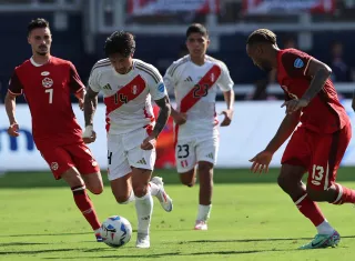 El canadiense Stephen Eustaquio (i) disputa un balón con el peruano Gianluca Lapadula (c). /Foto: EFE