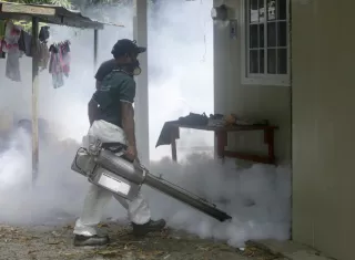 Un funcionario del Ministerio de Salud realiza fumigación.