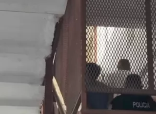 Los asesinos son custodiados por policías.