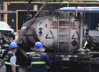 Inspeccionan donde ocurrió incendio de dos camiones de combustible.