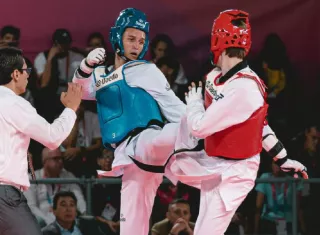 Ian Romero (izq.), atleta del taekwondo, durante uno de sus combates de la jornada de ayer miércoles, en la que consiguió medalla de bronce en la categoría de los 68 kilogramos.