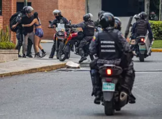 Guardia Nacional Bolivariana (GNB) detienen a dos personas durante protestas. Foto: EFE