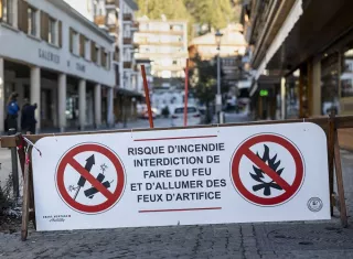 Vista de un cartel que prohibe los fuegos artificiales por riesgo de incendio en el lugar en el que "decenas de personas han muerto" en un incendio registrado en las primeras horas del año en la popular estación de esquí suiza de Crans Montana. Foto: EFE