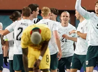 Jugadores de Austria celebran ante el lamento de un jugador de Ghana.