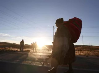 Una persona camina por una carretera bloqueada con escombros este sábado en Achica Arriba (Bolivia). Foto: EFE