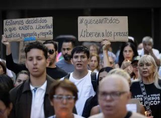 Personas sostienen carteles durante una vigilia este viernes, en Caracas (Venezuela)./ EFE