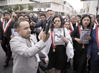 Congresistas de Perú sostienen carteles tras abandonar el Congreso segundos antes de que la nueva presidenta peruana, Keiko Fujimori, iniciara su discurso a la nación. Foto. EFE