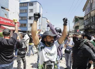 Rescatistas y voluntarios levantan los brazos pidiendo silencio durante una operación de rescate en los escombros de un edificio en el sector de La Lorena en Pereira, Colombia. Foto. EFE 