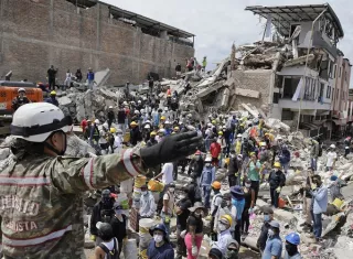 Una rescatista del Ejercito de Colombia da indicaciones a un grupo de voluntarios que realiza labores de búsqueda en edificaciones destruidas por el terremoto de magnitud 7,4. Foto. EFE