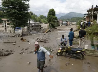 Campesinos avanzan entre el lodo en Trishuli, en el distrito nepalí de Nuwakot, tras una riada repentina.  Foto. EFE