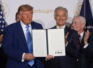 El presidente de Estados Unidos, Donald Trump (i), posa con un documento durante la presentación del portal America.gov, que emplea IA para reunir en una sola plataforma los servicios administrativos de las agencias gubernamentales. Foto. EFE