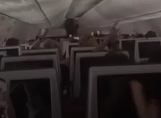 Los pasajeros celebran luego de lograr aterrizar después del incidente dentro de la aeronave de FlyDubai. Foto. Captura de Video