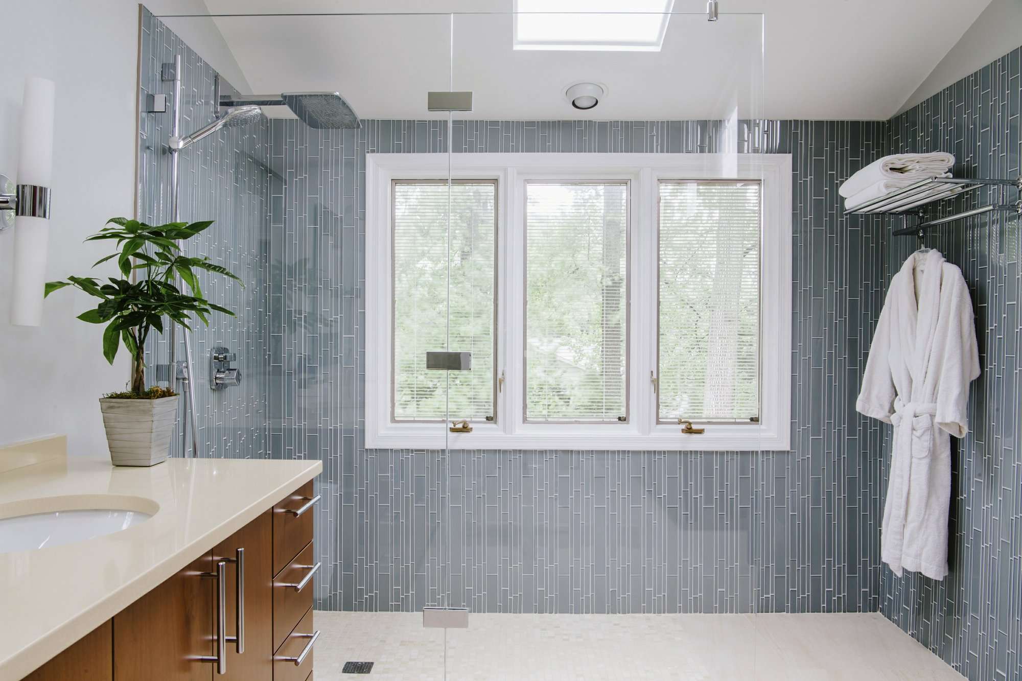 La diseñadora de interiores Nadia Subaran dice que los propietarios de viviendas cada vez más quieren duchas con mampara de vidrio en las que puedan caminar directamente sin ningún paso ni puerta, como se ve en este diseño de Aidan Design. AP