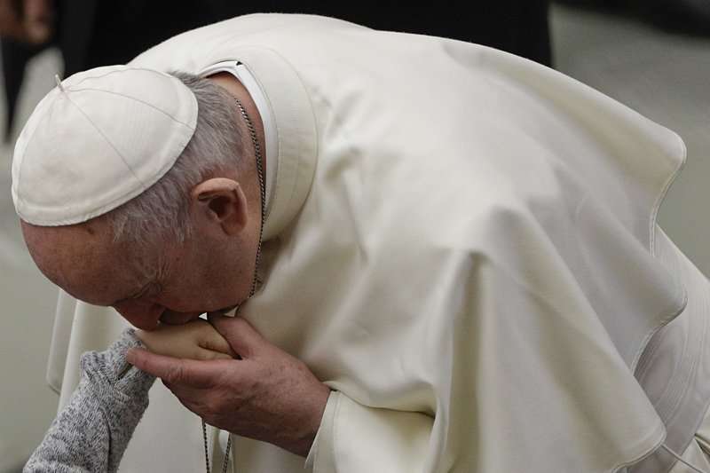 El Papa Francisco besa la mano de un niño durante la audiencia general semanal en el Vaticano. Foto: AP 