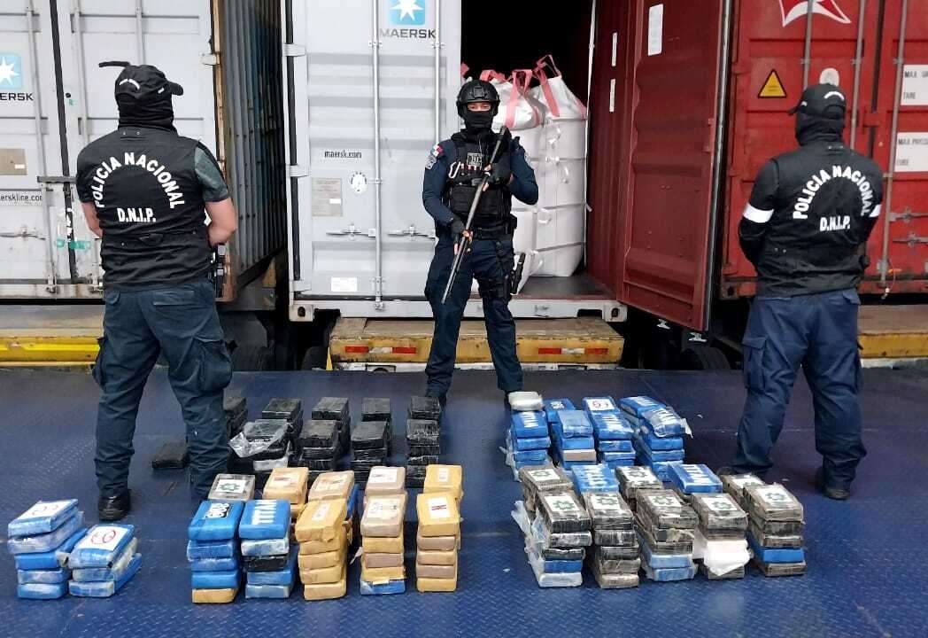 Los agentes policiales custodian los paquetes de droga.