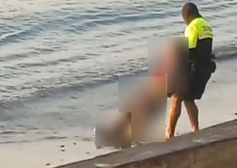 Una unidad policial extrae el cuerpo de la playa.