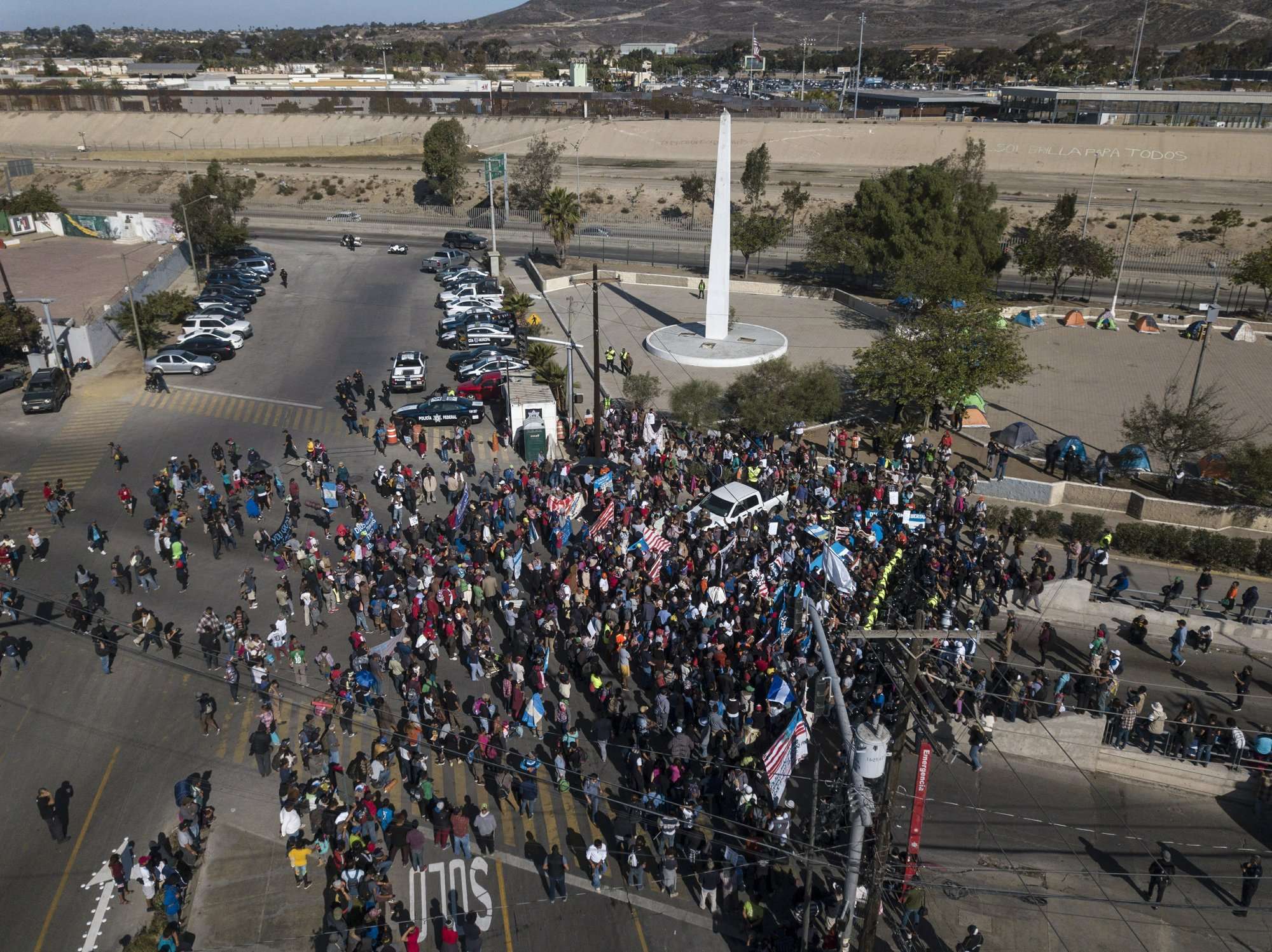 Migrantes se reúnen en el cruce fronterizo Chaparral, entre Tijuana, México y EE.UU.  Foto: AP