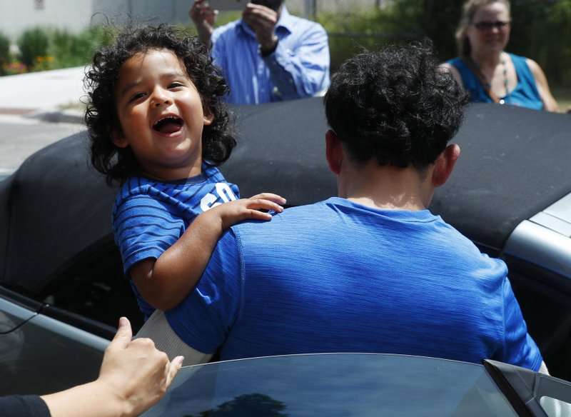 Ever Reyes Mejía, de Honduras, lleva a su hijo a un vehículo después de reunirse y ser liberado por el Servicio de Inmigración y Control de Aduanas de los Estados Unidos en Grand Rapids, Michigan. Foto: AP