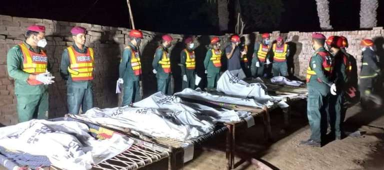 La policía de Pakistán con los cadáveres de las mujeres y los niños incinerados presuntamente por un padre molesto con la boda de una de ellas. 