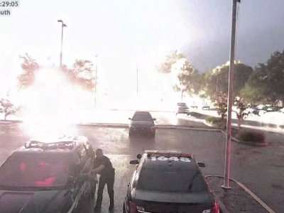 Un ofical de cía de Florida que cargaba su vehículo sufrió un gran impacto cuando un rayo cayó en el estacionamiento detrás de él. Foto: AP