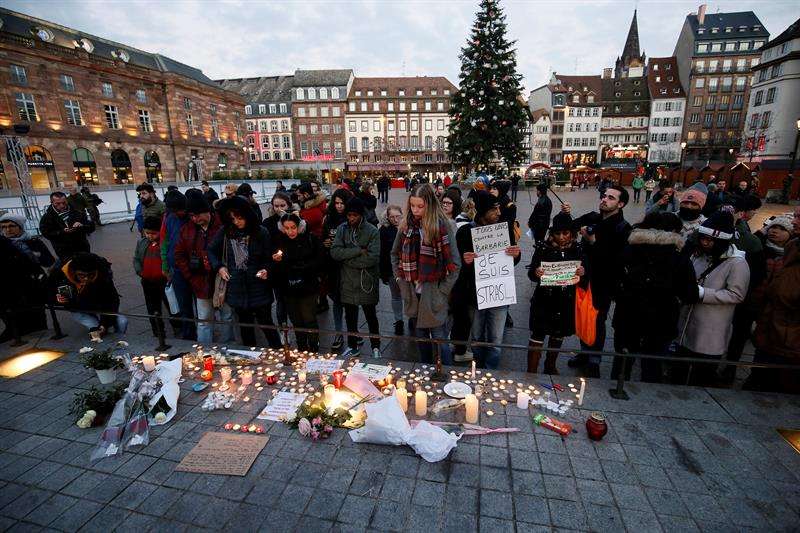 Ciudadanos encienden velas y escriben mensajes hoy, 12 de diciembre de 2018, en el lugar donde falleció una de las víctimas en el atentado en Estrasburgo (Francia). EFE