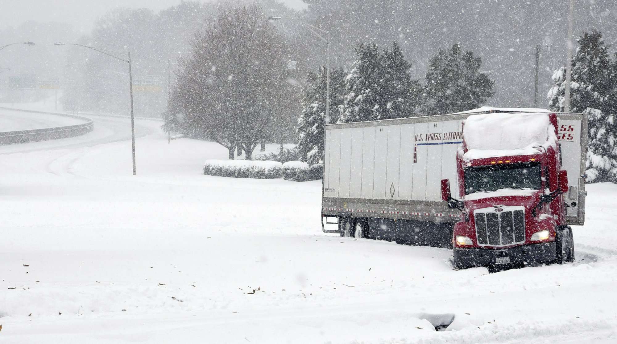 Un remolque de tractor está atascado en una rampa de salida de Business I-40 hacia Stratford Road, US 158, mientras cae nieve en Winston-Salem, NC (Walt Unks / Winston-Salem Journal a través de AP)