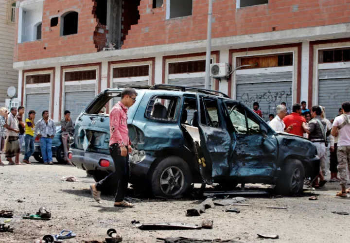 La gente camina en el área del ataque en Aden.  /  Foto: AP