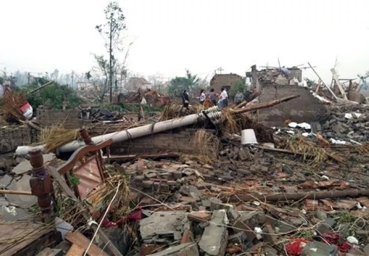 Los residentes pasan casas destruidas en las secuelas de un tornado que sacudió el distrito de Funing, en la ciudad de Yancheng en la provincia oriental china de Jiangsu.  /  Foto: AP