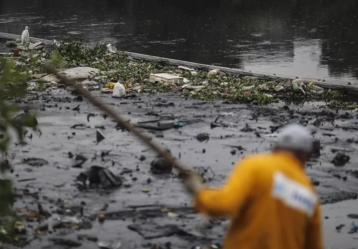 Un hombre   limpia el río Meriti, que desemboca en la Bahía de Guanabara, sede de las pruebas de Vela en los Juegos Olímpicos de Río 2016. Foto EFE