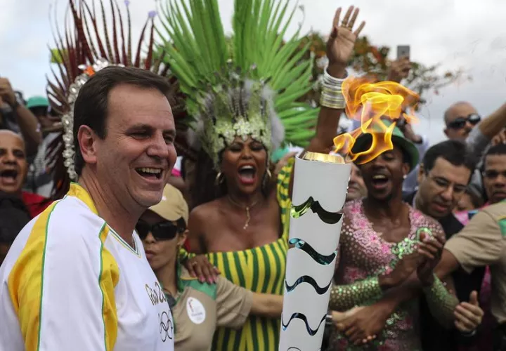 El alcalde de Río de Janeiro, Eduardo Paes (i), recibe la antorcha olímpica. Foto EFE