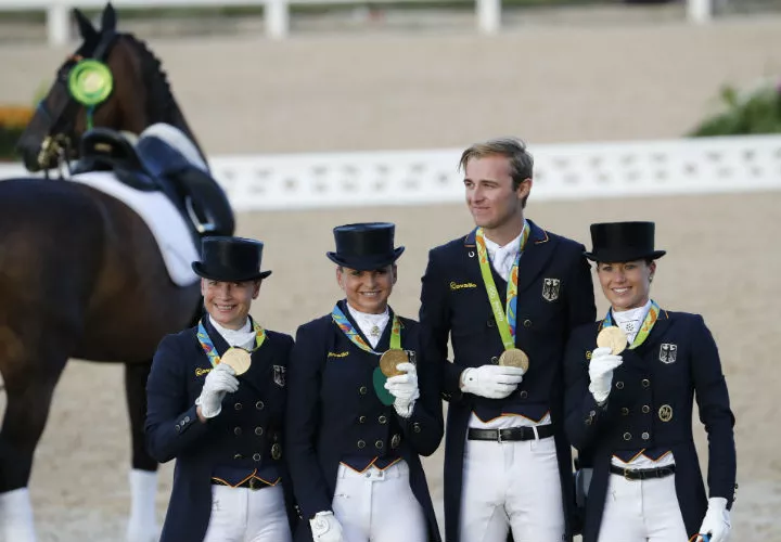 Los jinetes alemanes Isabell Werth, Kristina Broring-Sprehe, Sonke Rthenberger y Dorothee Schneider lucen sus medallas doradas. Foto EFE