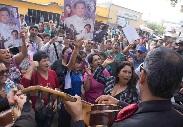 Seguidores del fallecido artista mexicano Juan Gabriel cantan como homenaje.  /  Foto: EFE