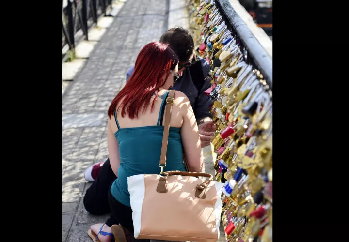 En la imagen, una pareja se dispone a colocar un candado en el Puente Nuevo de París para mostrar su amor perpetuo. EFE