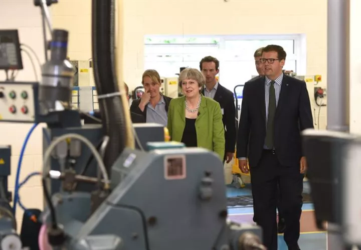 La primera ministra del Reino Unido, Theresa May (c), recorre las instalaciones de una fábrica durante un acto de campaña en Bath (Reino Unido). / Foto: EFE