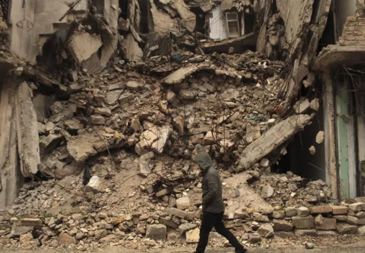Un hombre camina junto a un edificio derruido por los bombardeos en Siria. EFE/Archivo
