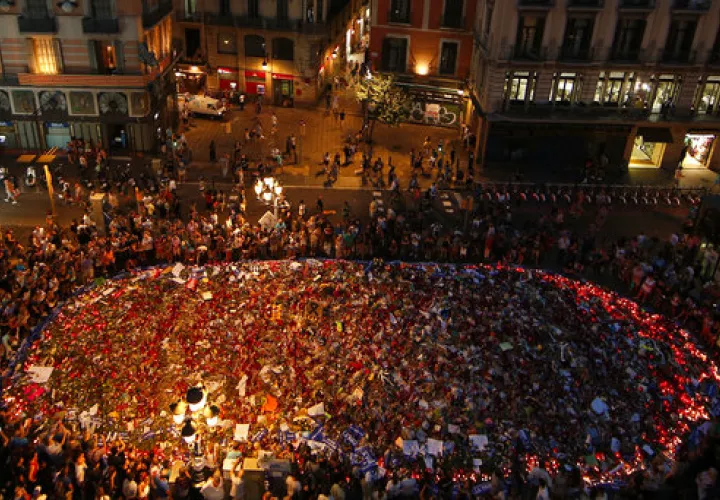 La gente está de pie en torno a un homenaje conmemorativo de flores, mensajes y velas en el histórico paseo marítimo de Las Ramblas de Barcelona.  /  Foto: AP