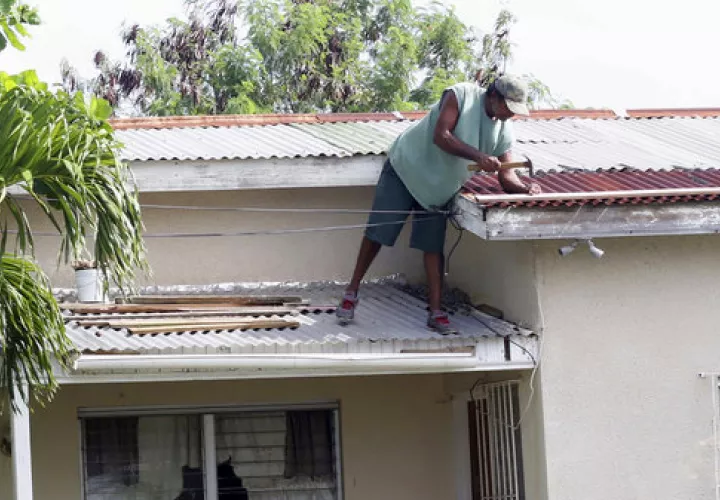 Previo al paso de Irma un hombre realizaba reparaciones de última hora a su techo antes de la llegada del huracán Irma, en St. John's, Antigua y Barbuda.  / Foto: AP Archivo
